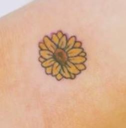 Piccolo girasole colorato tatuato interno polso