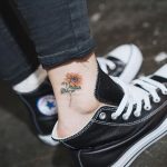 Tatuaggio Felicita e Gioia Simbolo girasole tatuato sulla caviglia