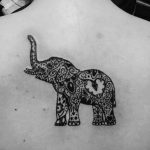 Tatuaggio femminile sulla schiena elefante con proboscide sollevata