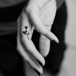 Piccola rosa tatuata sul dito della mano