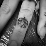 Piccolo fior di loto tatuato sul dito della mano
