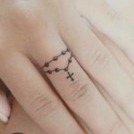 Piccolo rosario tatuato sul dito della mano