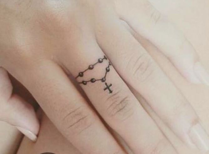 Piccolo rosario tatuato sul dito della mano