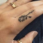 Piccolo tatuaggio di una rosa tatuata sul dito della mano
