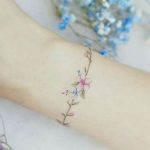 Elegante e delicato tatuaggio bracciale polso con fiori colorati
