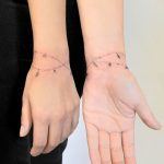 Immagine tatuaggio bracciale donna con piccoli charms