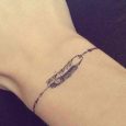 Piccolo tatuaggio bracciale polso con piuma