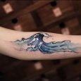 Idea tatuaggio onda del mare colorata sul braccio