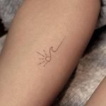 Piccolo tatuaggio femminile onda con sole