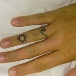 Piccolo tatuaggio sul dito onda con sole