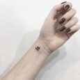 Piccolo tatuaggio interno polso del simbolo OM