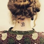 Tatuaggio simbolo OM alla base del collo