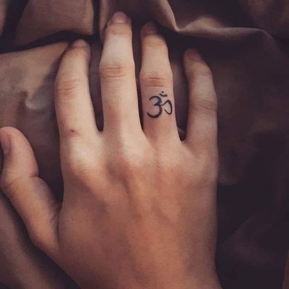 Tatuaggio simbolo OM sul dito